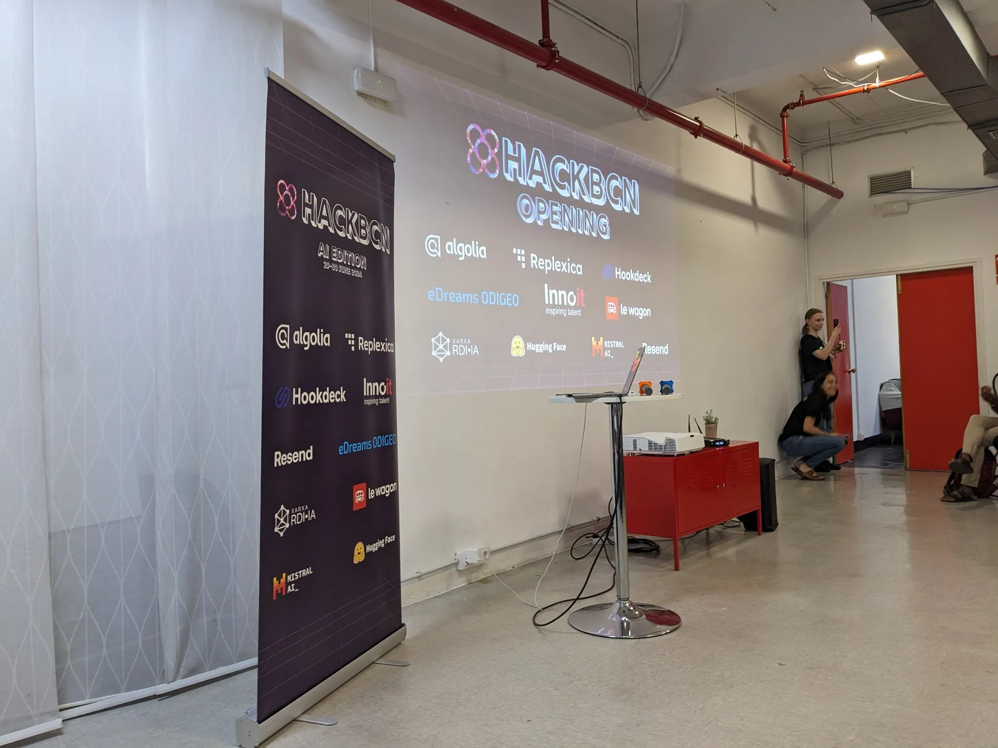 HackBarna - AI Edition - stage with poster including Hookdeck logo